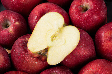 close up of fresh red delicious apples cut in half background. 