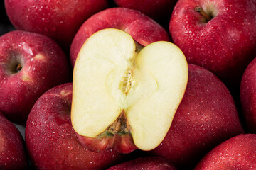 close up of fresh red delicious apples cut in half background. 