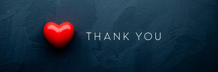 Minimalist "Thank You" message in white text beside a red heart on a dark textured background, creating a simple yet elegant expression of gratitude and love.

