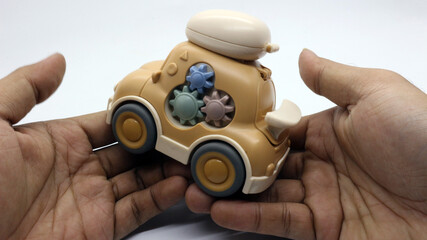 A brown children's toy car that looks very cute