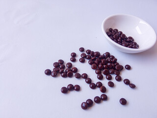 Chocolate coated peanut candy or chocolate balls isolated on white background