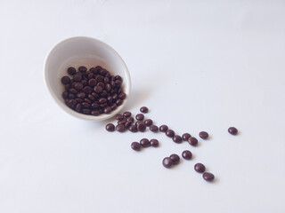 Chocolate coated peanut candy or chocolate balls isolated on white background