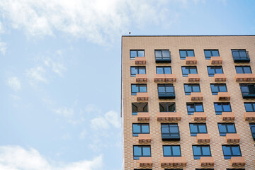 A Modern Apartment Building With Balconies Under a Clear Blue Sky During Daylight Hours in an Urban Setting