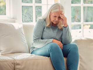 Stress, headache and senior woman in home with regret, worry or thinking of past trauma. Depression, retirement and sad person with mental health challenge, financial crisis or anxiety in living room