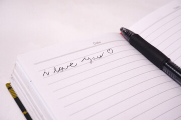 a note written "i love you" in a book with a pen 