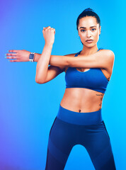 Gym, stretching and portrait of woman on blue background for health, wellness and warm up in studio. Personal trainer, fitness coach and isolated person for arm exercise, training and workout