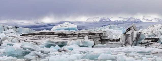 Fotobehang Gletsjer panorama of hundreds of colorful icebergs at Jökulsárlón Galcier Lagoon with the glaciers and mountains of Vatnajökull in the background, Iceland  © Hodossy