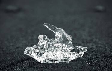 close-up of a glassy piece of ice on the black sand beach, Fellsfjara (Diamond beach), Jökulsárlón Glacier Lagoon, Iceland