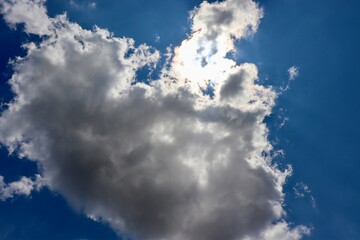 The fluffy cloud in the bright blue sky.