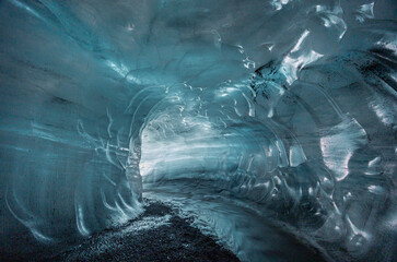the blue tunnel of Katla Ice Cave, with wave-like semi transparent ice wall, Vík, South Iceland