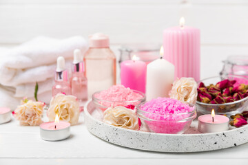 Sea salt for bath with aroma and rose flowers on textured wooden background. Pink sea salt. Spa treatments. Natural salt with herbs and essential oils. skincare concept. Meso for text. Copy space