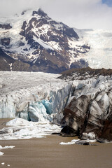 The lagoon of Svínafellsjökull outlet Glacier with emerging icebergs with mountains, Iceland

