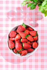 strawberries in a bowl on a pink background