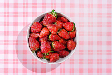 strawberries in a bowl on a pink background