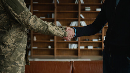 Unknown males men handshake unrecognizable man soldier military officer warrior guy in camouflage uniform shaking hands businessman male agreement partnership support gratitude greeting indoors office