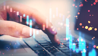 Closeup of a person's hand typing on a keyboard with digital financial graphs and bokeh lights...
