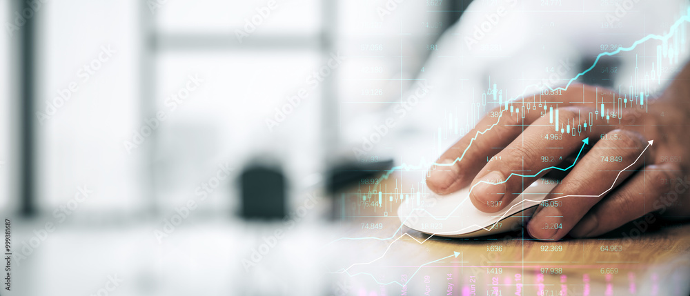 Poster businessperson using a mouse on a wooden desk with financial graphs overlayed on the image.