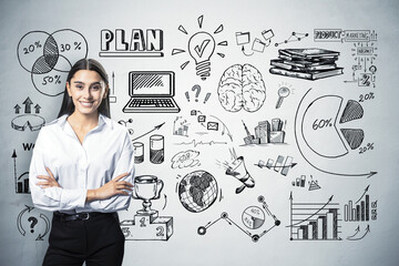 Smiling businesswoman in front of wall with business sketches and diagrams.