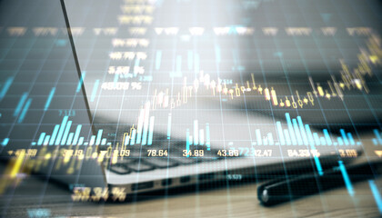 Double exposure of financial chart over a laptop and pen on a desk surface.