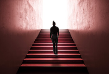Woman climbing staircase towards bright light, representing ambition and progress.
