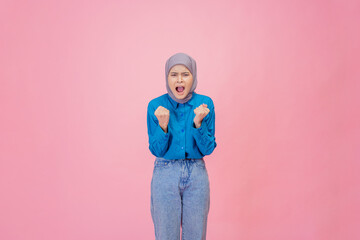 A joyful woman expresses excitement with clenched fists and a bright, happy smile