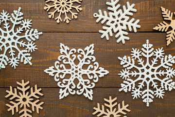 Beautiful snowflake on wooden background, top view