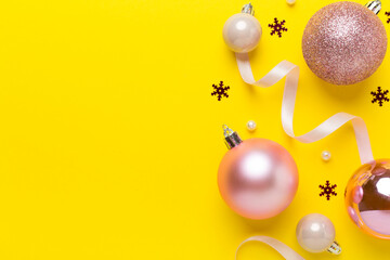 Pink christmas balls with decor on color background, top view