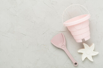 Cute toys for playing with sand on concrete background, top view