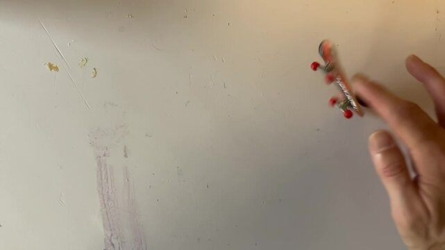 top shot of awesome flip trick while fingerboarding, male hands on finger board, 4k footage.