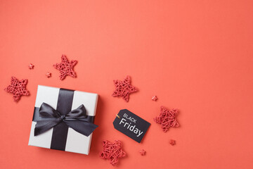Black Friday sale banner concept, Gift box with black ribbon bow on red background. Top view, flat lay