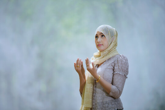 Portrait of a Muslim woman raising her hands for prayer, Thailand