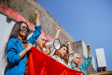 powerful woman with fist pump hand giving speech using megaphone on indonesian independence day