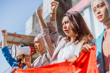 A diverse group of activists raising their fists and colorful banners during a protest