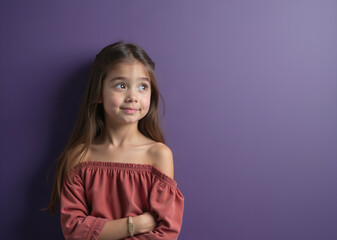 Fototapeta premium Young girl with curious expression looking up against purple background with copy space