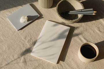 Overhead view of a Blank piece of card on a table with a cup of black coffee, pencils and assorted ceramics
