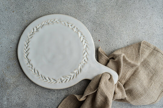 Overhead view of a rustic ceramic serving platter with a napkin