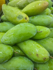 Fresh Green Mangoes Stacked at a Local Market Stall