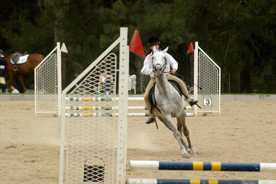 Teenage girl jumping over a hurdle at a show jumping event, Gauteng, South Africa