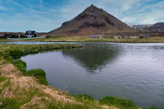 Black wooden house by a coastal mountain, Arnastapi, Snaefellsnes Peninsula, Iceland