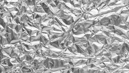 Crumpled bright shiny metallic silver aluminium foil background, flat lay view backdrop with copy space for text.