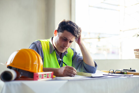 Caucasian man architect engineer construction tired and exhausted working on blueprint design plan using pencil tool planning analyzing design innovation to building landscape housing architecture.