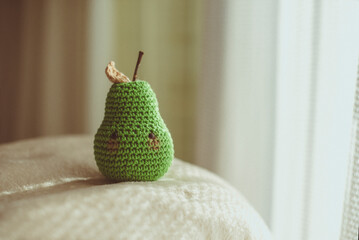 Close up of a crochet pear toys (Amigurumi) on a stool