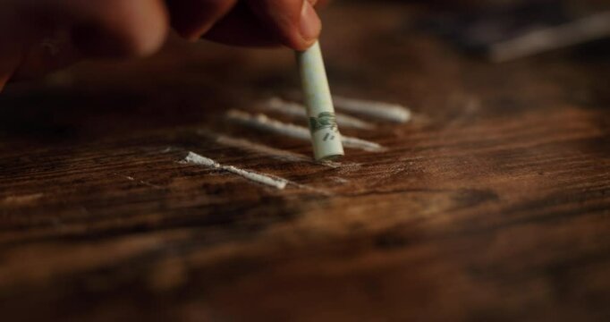 Hands, dollar bill and snorting with drugs, powder and addiction with substance abuse at event. Person, nightclub and party with cash to sniff narcotics, crime and illegal product at social lounge