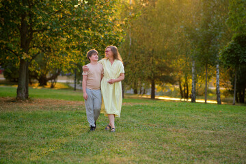 Fototapeta premium A portrait of a loving mother and her son spending quality time together in the beauty of nature. Capturing a beautiful day outdoors, a happy mother and her child smile brightly in the park.