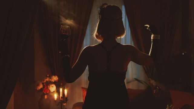 Old film style black dark mysterious female silhouette dancing. red wine glass holding hand. black sexy vintage dress 20s. retro young happy woman dancer at night club party have fun. room full smoke