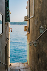 Charming waterfront alleyway in Rovinj, Croatia framed by tranquil Adriatic waters at dawn