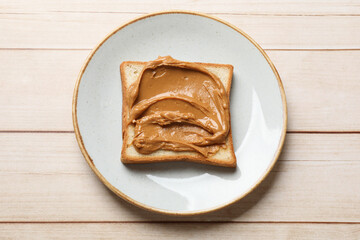 Delicious sandwich with peanut butter on white wooden table, top view