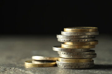 Stacked euro coins on grey table, closeup