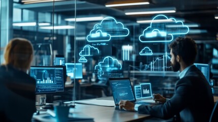 A professional workspace featuring two people analyzing data on laptops with digital cloud graphics and data visualizations displayed.