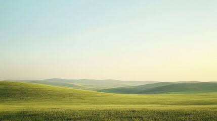 Obraz premium A wide-open field with rolling hills and a clear sky, offering ample space for text in the sky or foreground.